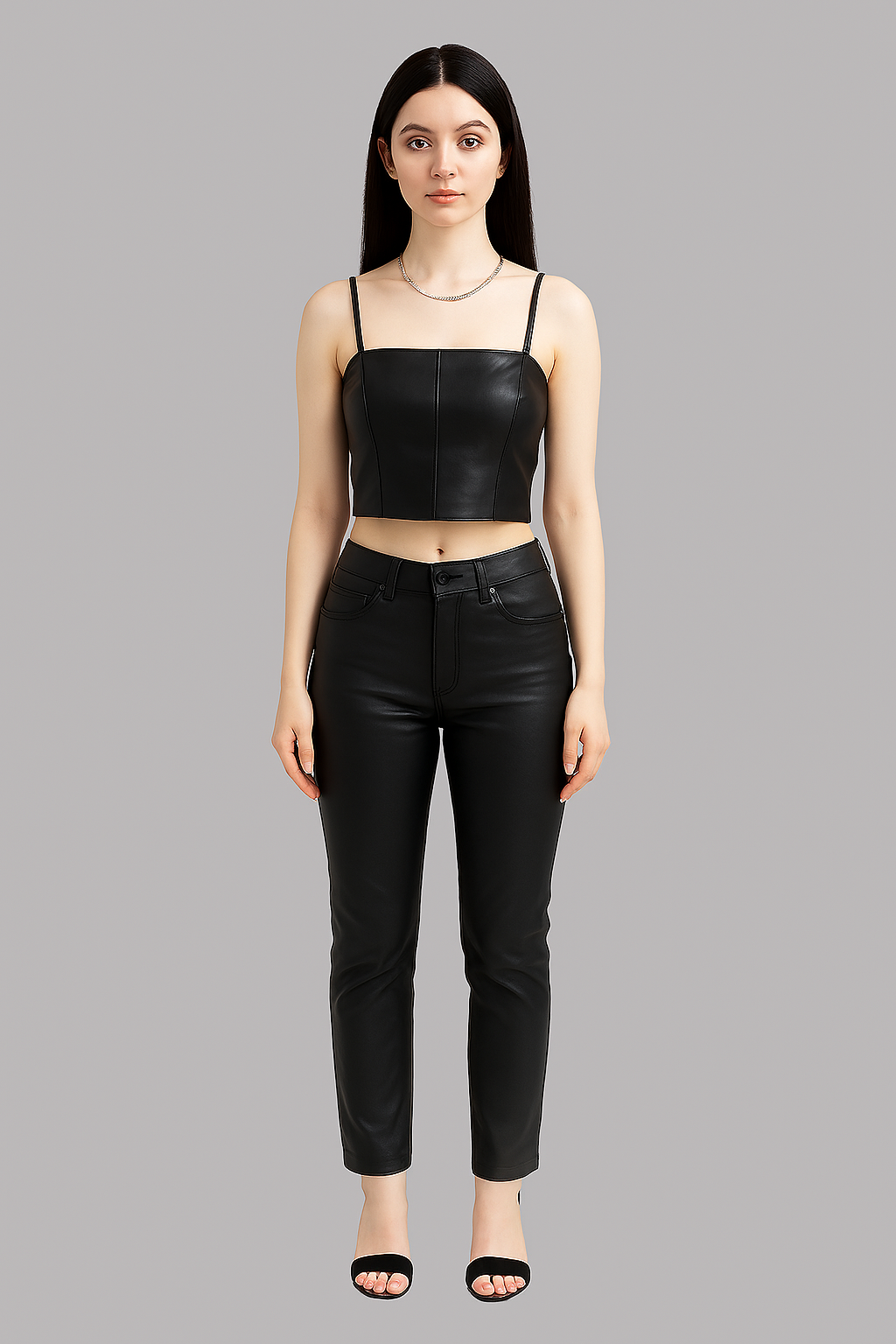 Woman wearing a black leather top and black pants on a gray background